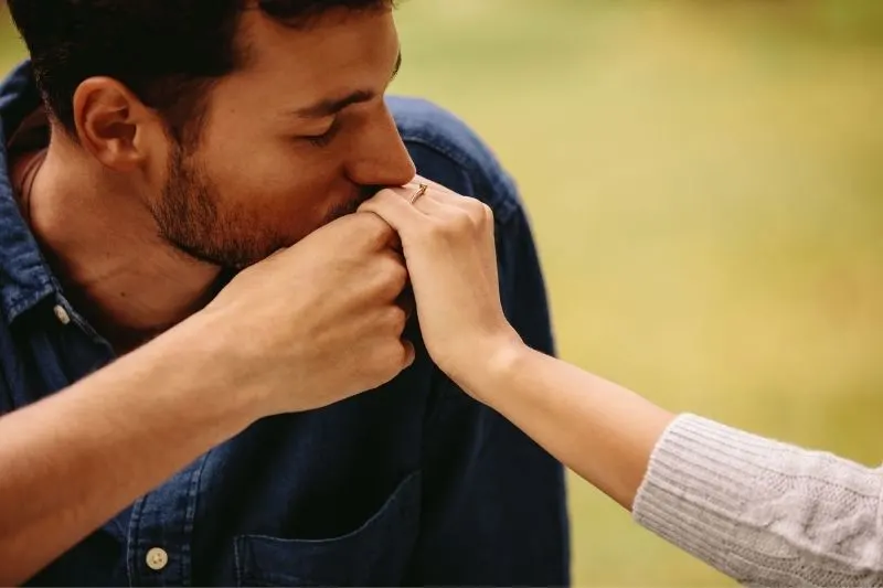 newly engaged couple man kissing the hand of a woman with ring on the finger