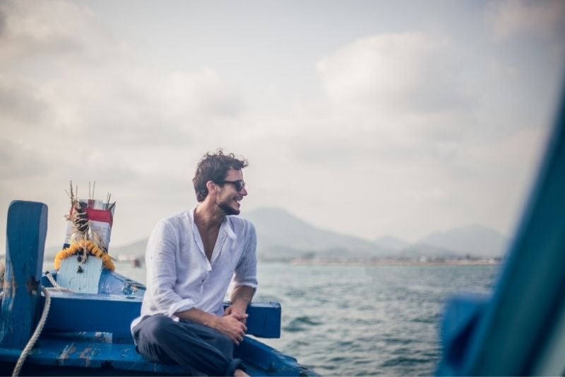 um homem no barco sentado e a relaxar junto ao mar