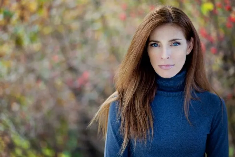 pretty serious mature woman wearing blue sweater outdoors