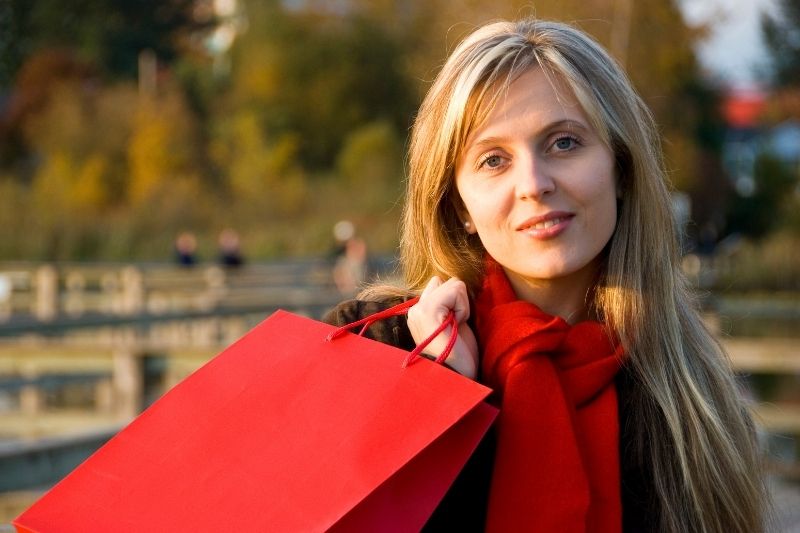mujer guapa llevando bolsas de la compra al aire libre