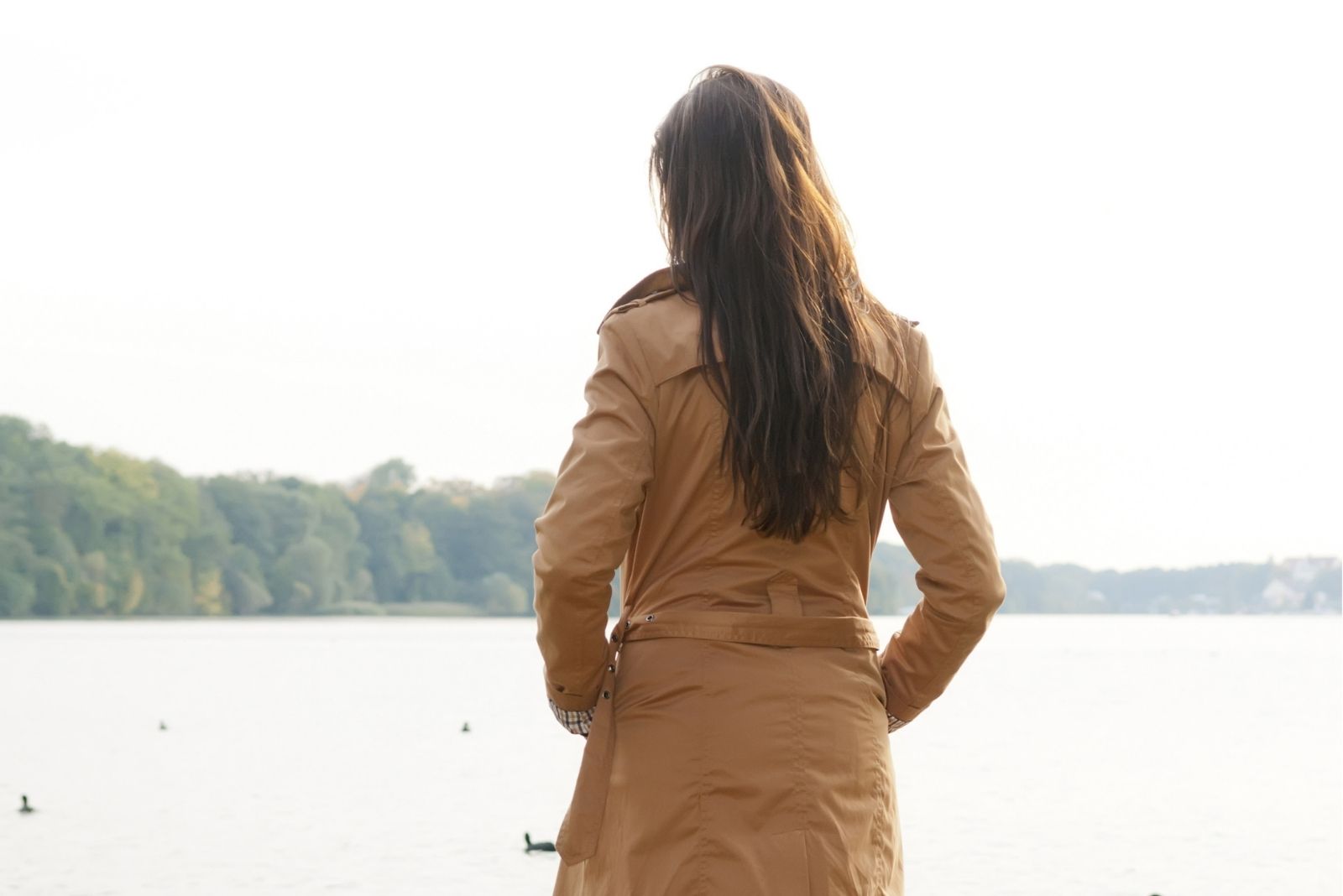 vista trasera de una mujer frente a un lago o cuerpo de agua