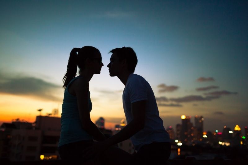 coppia romantica che si bacia in città in silhouette