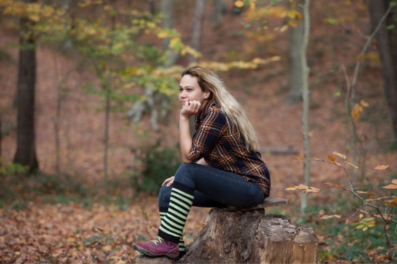 mujer sexy en el bosque sentada y pensando profundamente