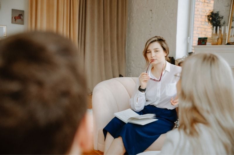 therapist listening to the couple having family conflict inside the livingroom