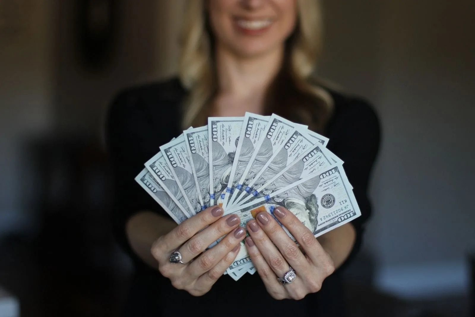 wealthy woman showing money in her hands in focus