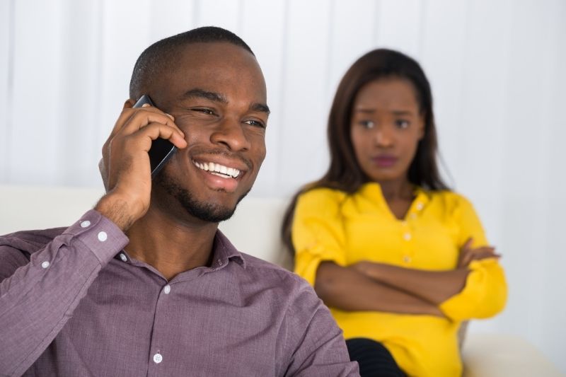 woman looking at the man in his cellphone anxiously 