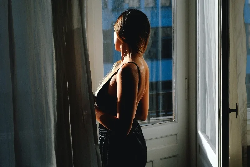 woman in black top looking outside