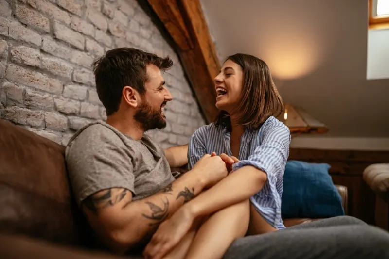 happy woman in striped shirt sitting in man's lap