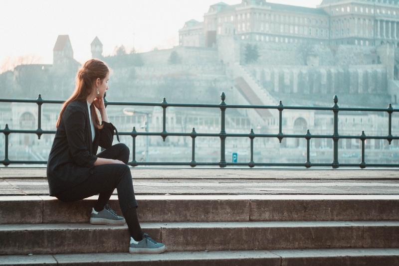 woman in black blazer sitting on stairs