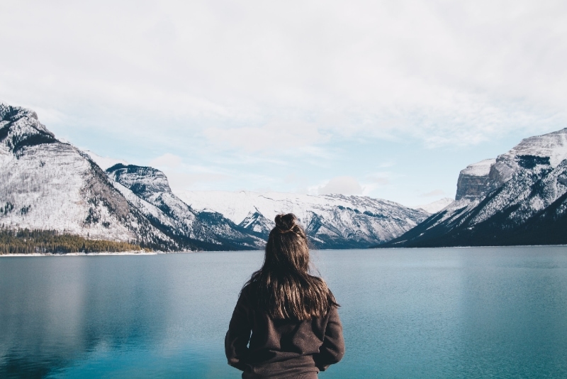 woman in black jacket standing near water