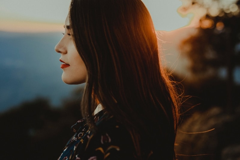 mujer en top floral de pie al aire libre durante la puesta de sol