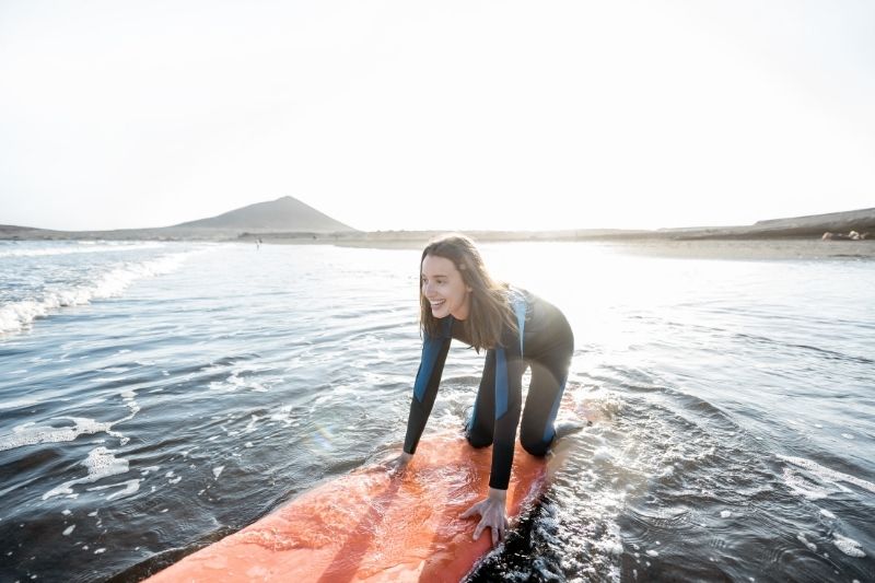 woman surfing at the sea early in the morning 