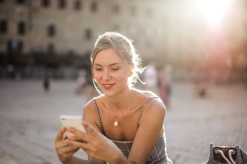 woman using smartphone while sitting outdoor