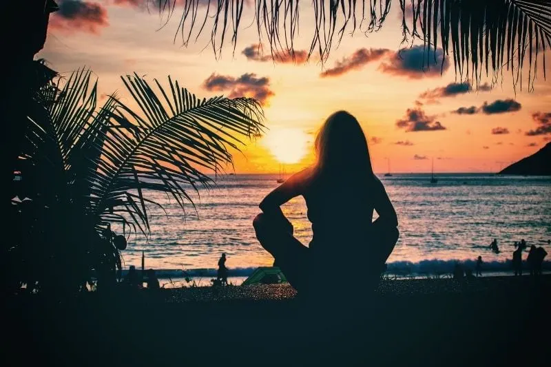 woman watching the sunset in Phuket Thailand near the beach while sitting