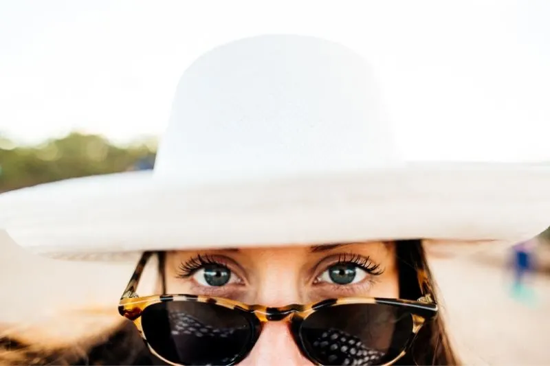 woman wearing hat and eyeglass showing the upper half of the face