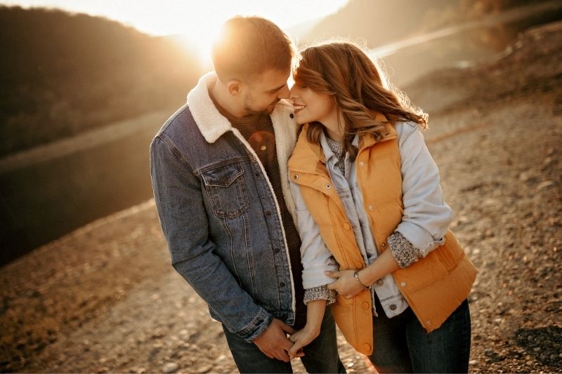 young couple walking under the sunshine near the mountains