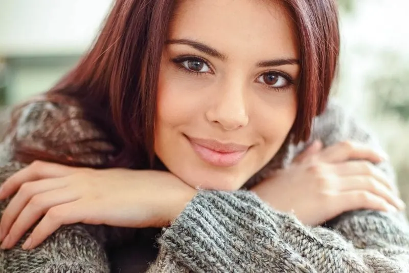 young happy woman wearing comfortable sweater at home