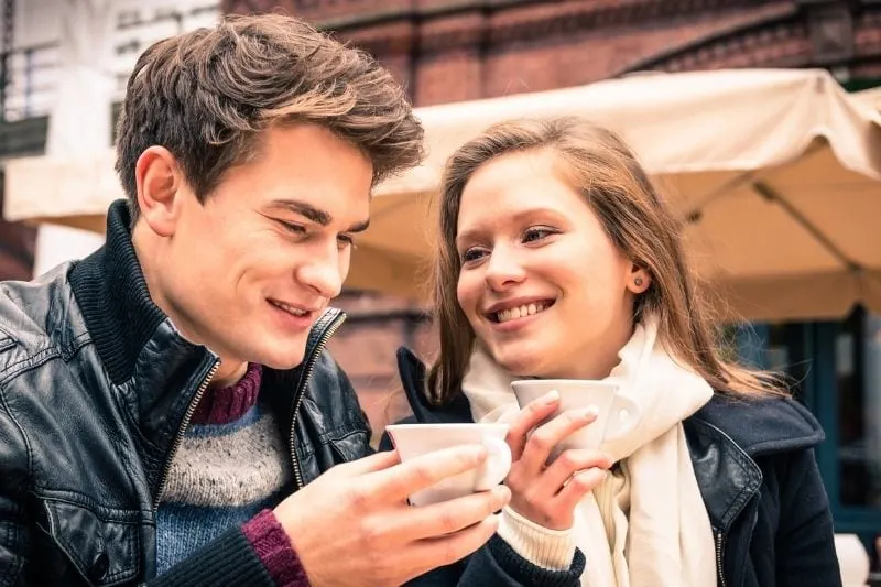 young lovely couple enjoying a cup of coffee outdoors