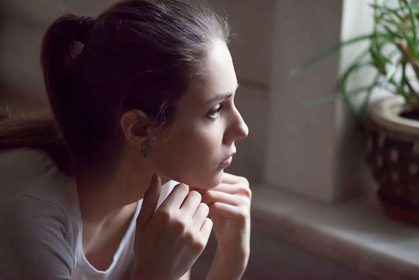 young pretty girl looking away while reflecting inside the house