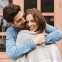 a man wrapping a girl in a blanket