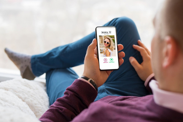 toop angle of a man looking at the picture of a woman in a dating app
