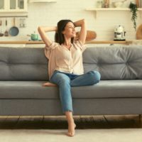 positive woman sitting on couch