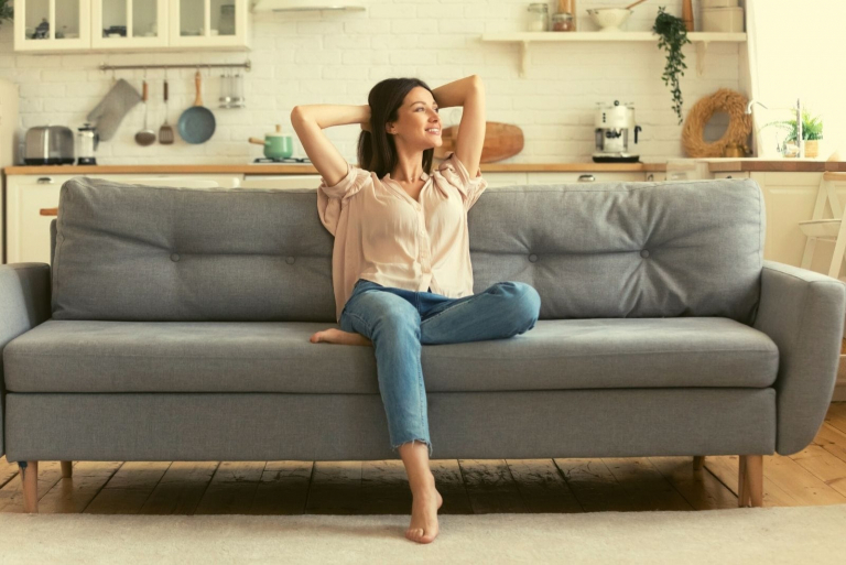 positive woman sitting on couch
