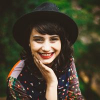 woman with black hat smiling outdoor