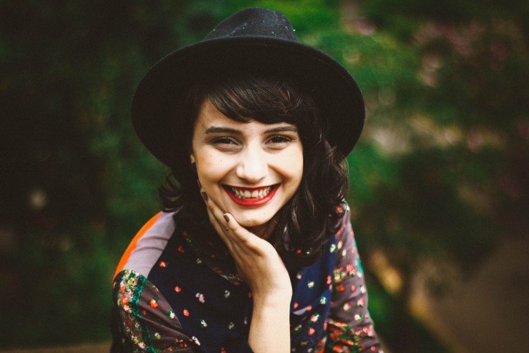woman with black hat smiling outdoor