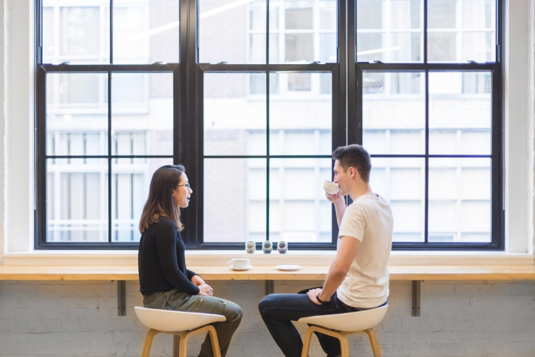 hombre y mujer hablando sentados a la mesa