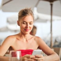woman looking at phone while sitting at table