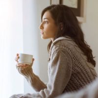 thoughtful woman holding a cup of tea