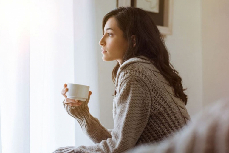 thoughtful woman holding a cup of tea