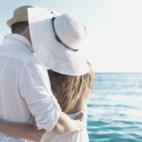 pareja feliz abrazada frente al mar en unas vacaciones a un lugar tropical