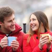 woman and man chilling out while drinking coffee outdoors