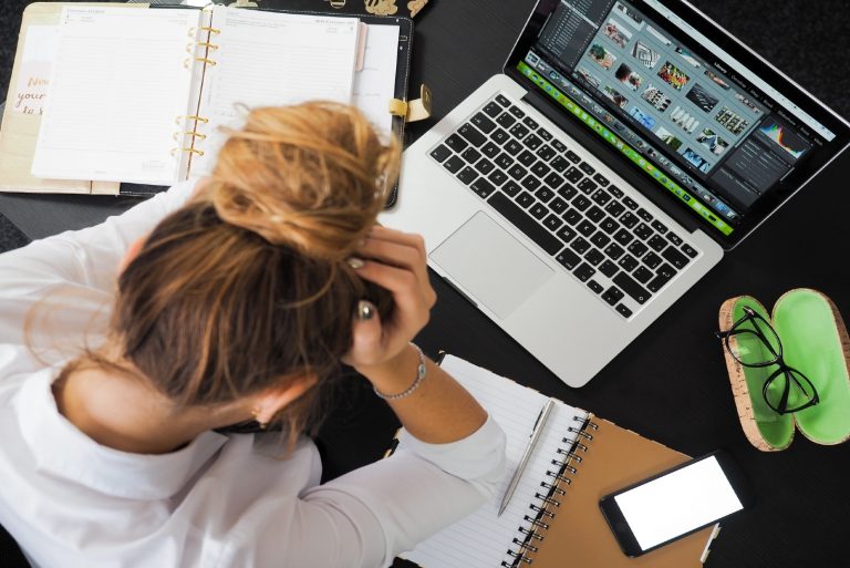 woman in white shirt sitting in front of laptop