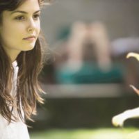 woman pensive and sitting outdoors