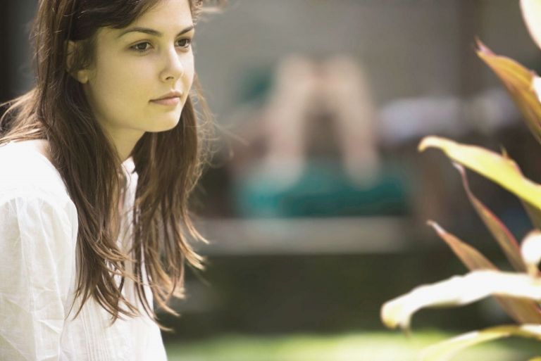 woman pensive and sitting outdoors
