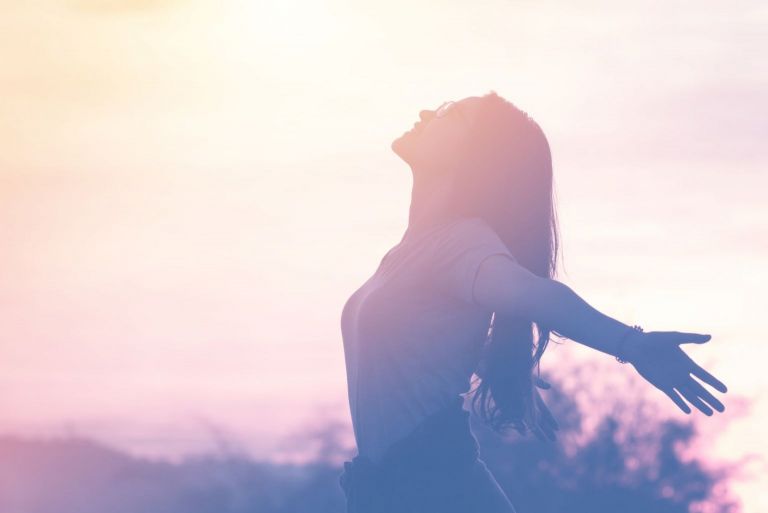 restful woman raising her hands