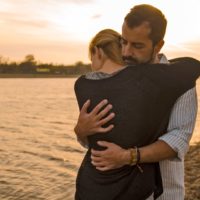 a man hugging a girl during sunset