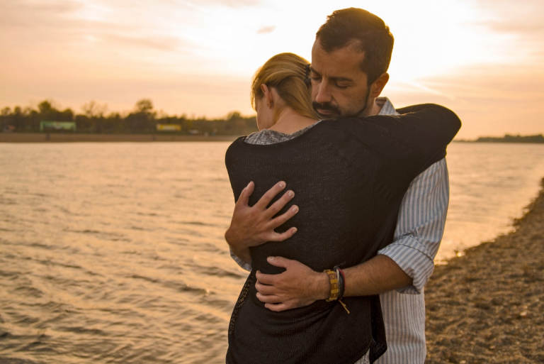 a man hugging a girl during sunset