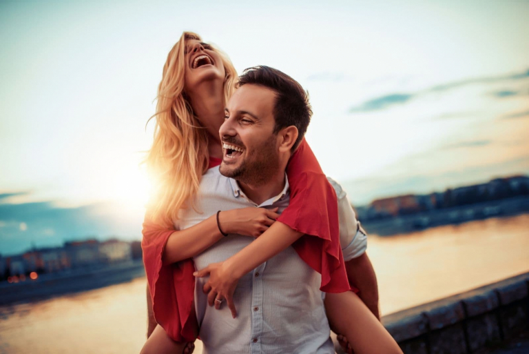 jovem casal feliz a andar de bicicleta ao ar livre