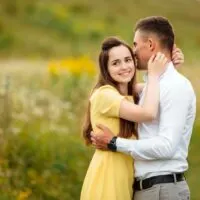 a couple in love embracing in a field standing