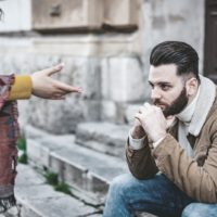 jovens casais caucasianos a discutir na rua homem sentado nas escadas