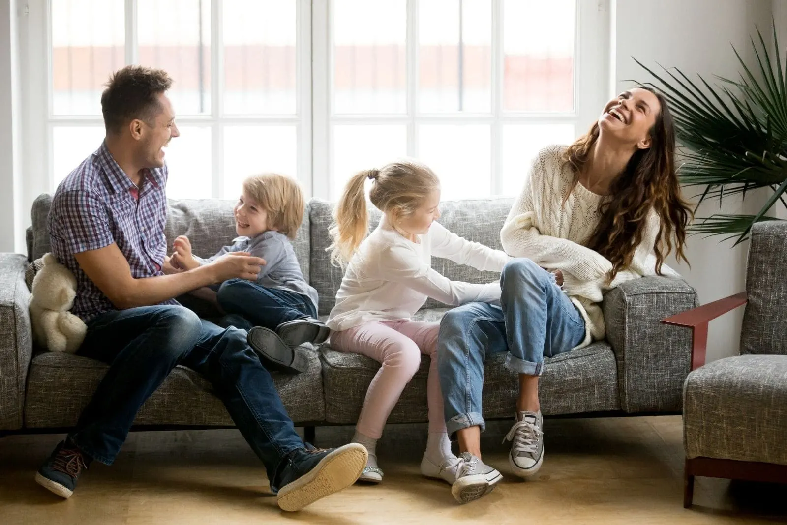 cheerful family playing in the livingroom sitting in the sofa laughing