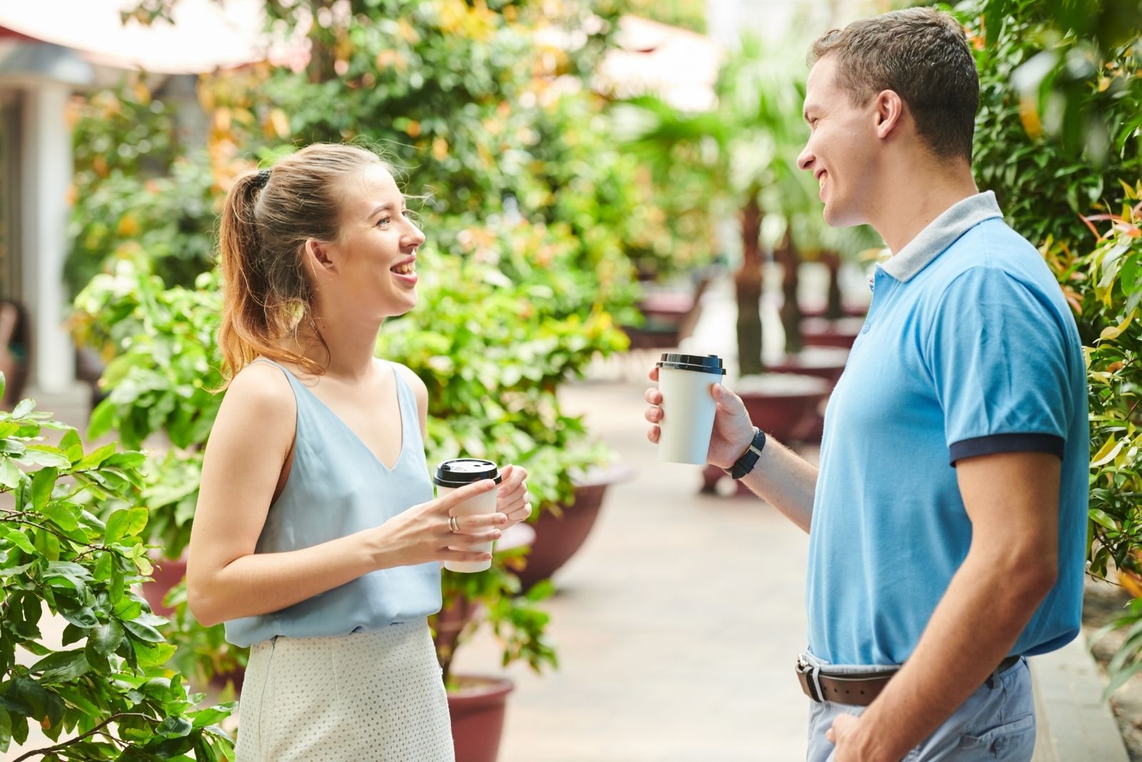 cheerful man and woman talking and joking while standing in the middle of the walkway