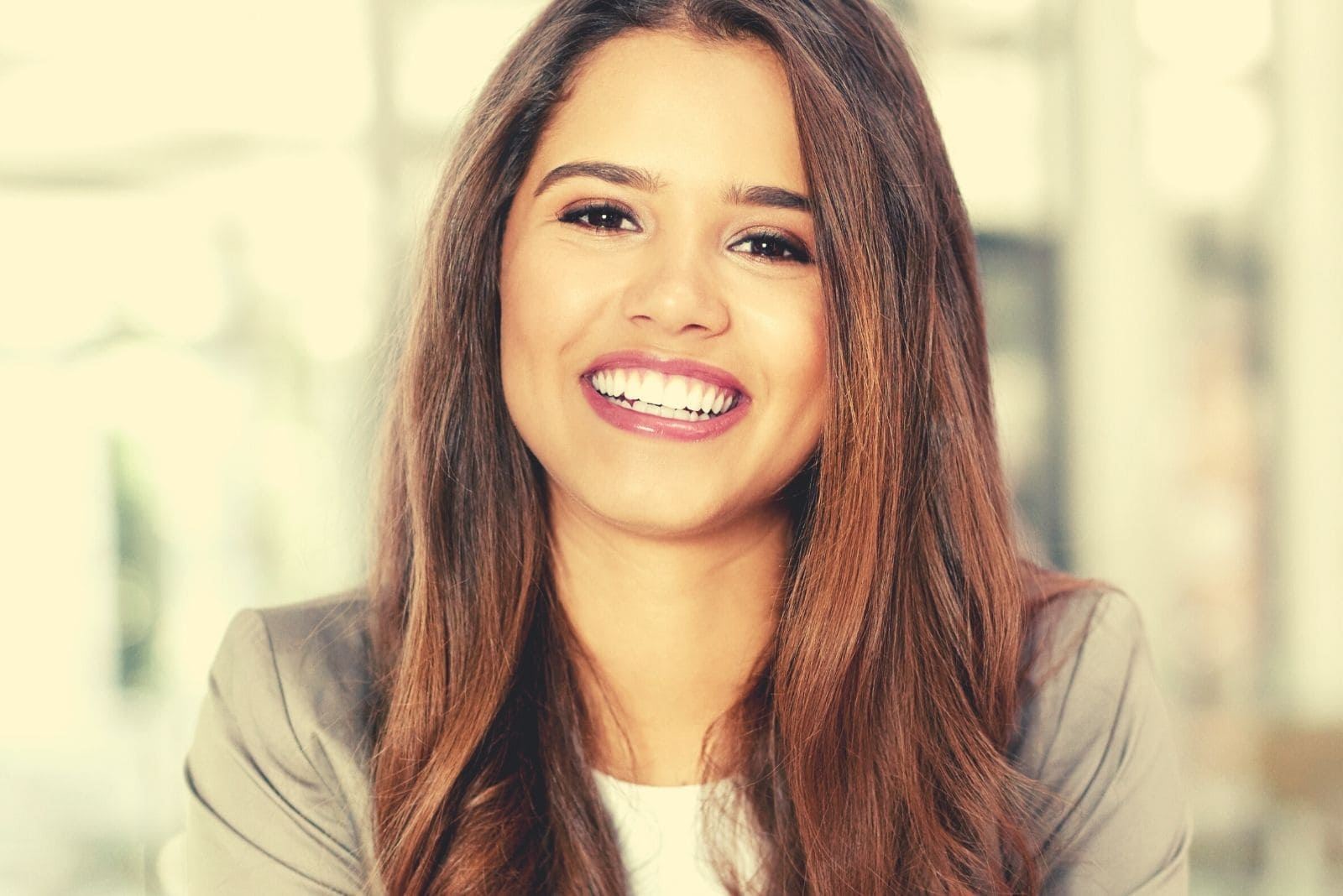 confident young businesswoman smiling and sitting in cropped image