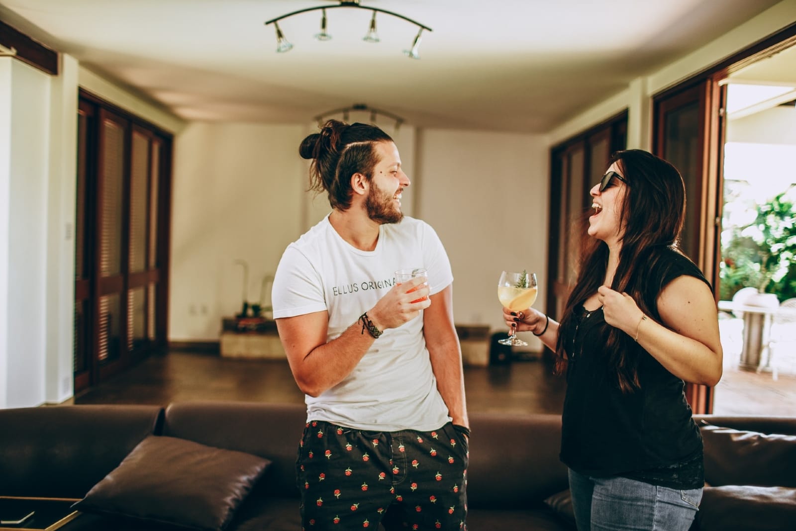 man and woman drinking cocktails while standing indoor