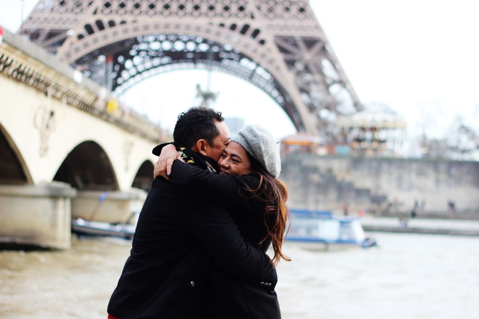 man and woman hugging while standing near water