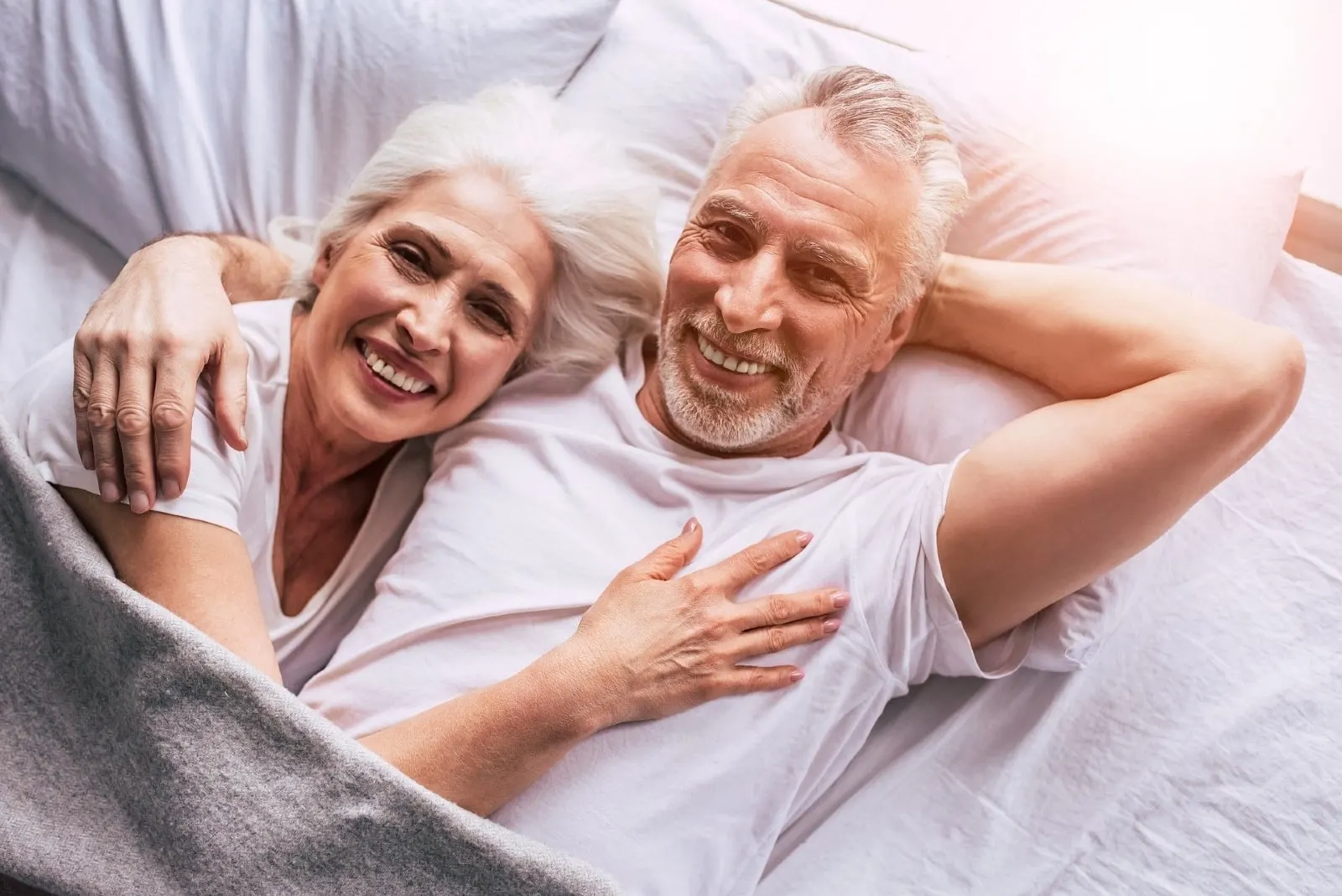 man and woman hugging while laying in bed